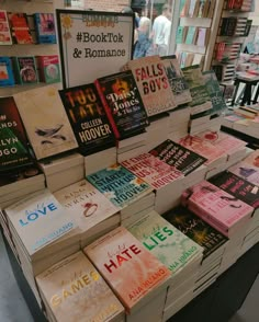 many books are stacked on top of each other in front of a book store display