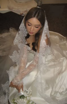 a woman in a wedding dress cutting into a cake