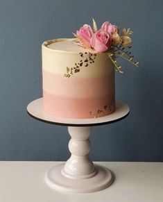 a pink and white cake with flowers on top