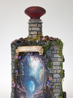 a bottle that is sitting on top of a brick wall with flowers and plants growing out of it