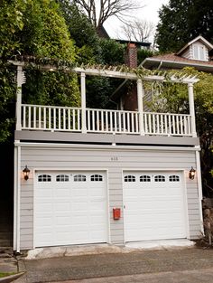 two garages with white doors and balconies