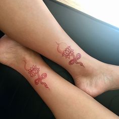 two people with tattoos on their legs sitting next to each other