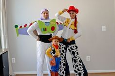 two adults and a child in costume standing next to each other with toy story characters on their costumes