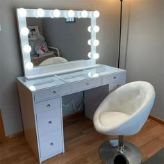 a white chair sitting in front of a vanity with a mirror and lights on it