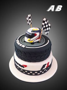 a birthday cake with a racing car on top and flags sticking out of the side