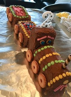 a cake shaped like a train on top of tin foil with numbers and candy decorations