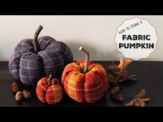 two pumpkins and some pine cones on a table