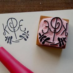 a stamp that has been placed on top of a piece of paper next to a pink pen