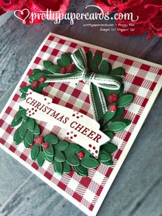 a close up of a christmas card on a table with red and white checkered fabric