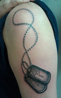 a woman with a tattoo on her arm has a dog tag and chain attached to it