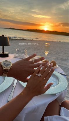 two people sitting at a table with their hands on each other's wrists