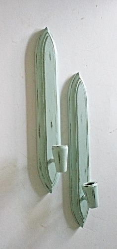 two green wall mounted mirrors on a white wall