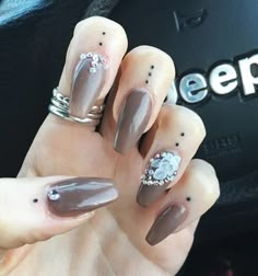 a woman's hand with some brown and silver nails