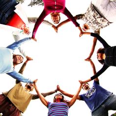 a group of people standing in a circle with their hands together