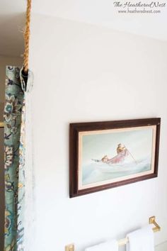 a painting hangs on the wall above a towel rack