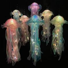 three jellyfish lights hanging from strings in the dark