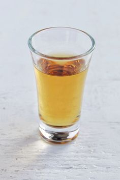 a glass filled with liquid sitting on top of a table