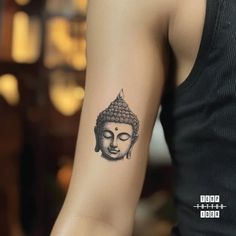 a person with a tattoo on their arm that has a buddha head in the middle