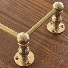 two brass knobs on a wooden table with one turned off and the other turned down