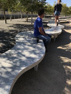 two people are sitting on benches in the park