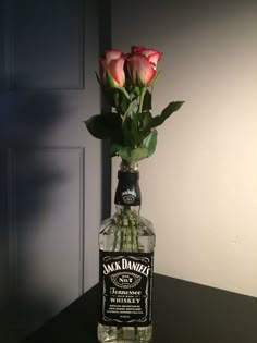 a bottle with roses in it sitting on a table