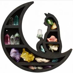 the moon shelf is filled with crystals and rocks to look like a cat sitting on it