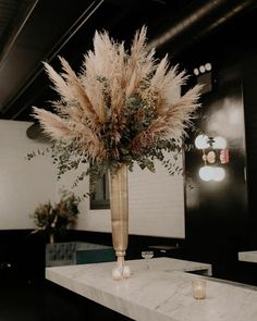 an instagram photo with a vase full of flowers and candles on the counter top