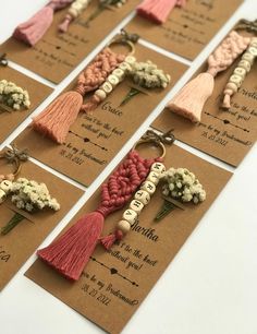 some tassels with flowers and letters on them are arranged in order to be used as keychains