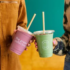 two people holding up cups with straws in them and the words the green collective