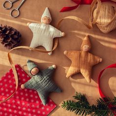 christmas ornaments are laid out on top of a piece of paper with scissors, pine cones and twine