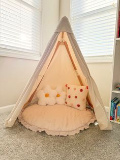 a child's teepeet bed with pillows on the floor