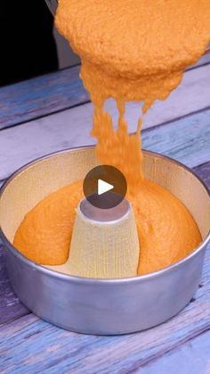 someone pouring orange sauce into a metal pan