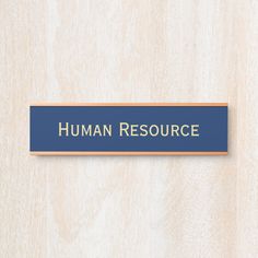 a blue sign that says human resources on the side of a wooden wall with wood paneling