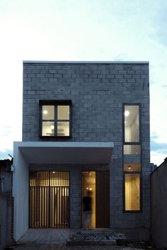 a person standing in front of a building with two windows on the side of it