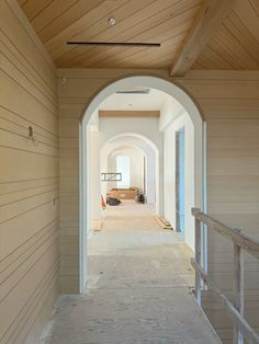 an archway leading into a room with wood floors and white walls that are being built