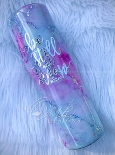 a purple and blue water bottle sitting on top of a white furnishing covered floor