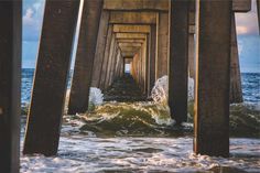 the underside of a pier with waves coming in