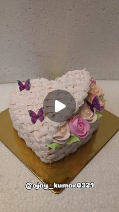 a heart shaped cake decorated with flowers and butterflies