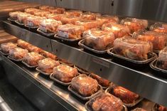 several trays of baked goods on display in a store or restaurant oven with glass covers over them