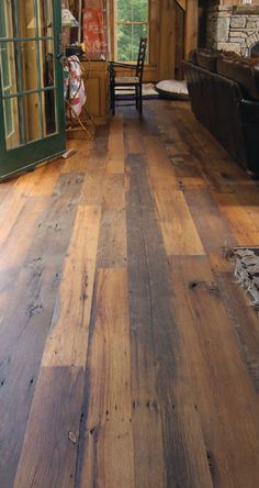 a wooden floor in a living room next to a window