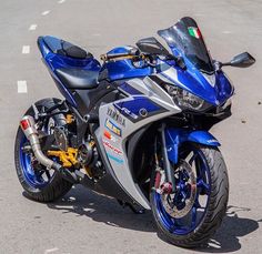 a blue and silver motorcycle parked on the street