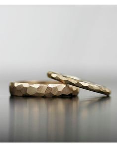 two gold rings sitting on top of a table