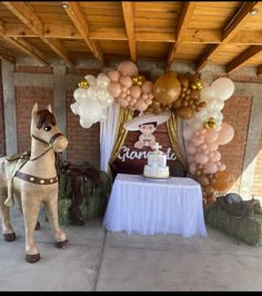 a horse statue next to a table with balloons