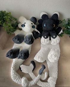 two crocheted stuffed animals sitting next to each other on top of a table