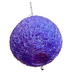 a purple ball hanging from a chain on a white background