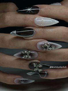 a woman's hand with black and white manies on her nails, decorated with silver