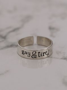 Are you gay & tired? Being gay can get a little exhausting, carrying the weight of being the most attractive, funniest, and best all-around friend and sibling. Product Details: Materials: Aluminum, Sterling Silver, Fine Silver, 14k Gold Filled Color: Silver, Gold, Rose Gold Size: 6mm You will receive one hand-stamped ring filled with a black enamel finish. Gay Rings, Tire Rings, Masc Lesbian, Stamped Ring, Hand Stamped Ring, Stamped Rings, Black Enamel, Fine Silver, Gold Rose