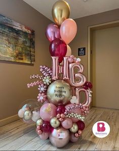 a large balloon sculpture with balloons and flowers on the bottom that says happy birthday mother