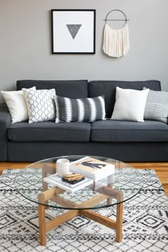 a living room with a couch, coffee table and pictures on the wall above it