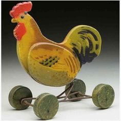 a yellow and black rooster is on top of some green wheels with two red feet